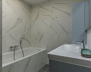 Bathroom with bathtub in Zilte Bries vacation home, De Koog, Texel, for ultimate relaxation.