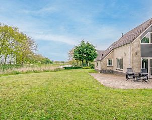Spacious terrace at Holiday home Honeysuckle 45, De Koog, Texel, overlooking a green garden.
