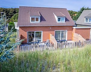 De Duinroos vacation home in De Koog, Texel with charming facade and surrounded by dunes.