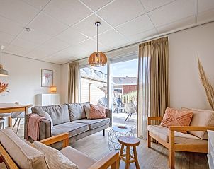 Cozy living room of De Duinroos in De Koog, Texel with comfortable sofas and lots of light.