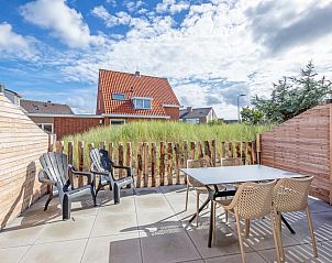 Sunlit terrace of De Duinroos in De Koog, Texel, with comfortable seating.