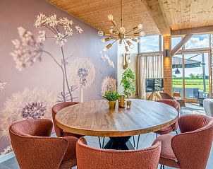 Dining area in Villa 187 with Hot tub, De Koog, Texel with stylish lighting and views of the green landscapes of the Wadden Islands.