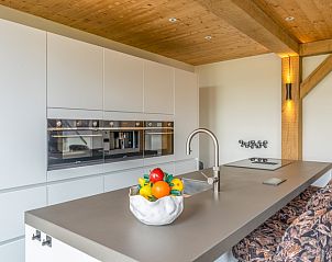 Sleek kitchen design in Villa 187 with Hot tub, De Koog, Texel with elegant finishes and views of the nature of the Wadden Islands.