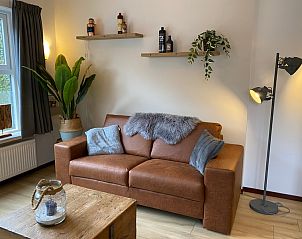 Stilvolles Wohnzimmer des Ferienhauses Jutter in De Koog, Texel. Bequemes Sofa und stimmungsvolle Dekoration.