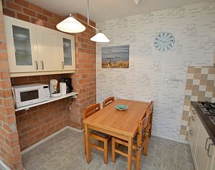 Cozy dining area in Apartment Kerckeland 16 in De Koog, Texel with wooden table and brick wall.