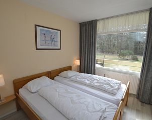 Bedroom of Apartment Kerckeland 16 in De Koog, Texel with two single beds and garden view.