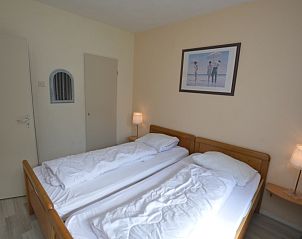 Cozy bedroom of Apartment Kerckeland 16 in De Koog, Texel with comfortable beds and atmospheric lighting.
