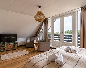 Spacious bedroom with balcony in cottage in De Koog, Texel, Wadden Islands.