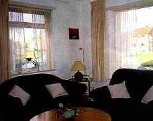 Gezellige woonkamer in Brink 9 vakantiehuis, De Koog Texel, met comfortabele zitruimte en veel natuurlijk licht.