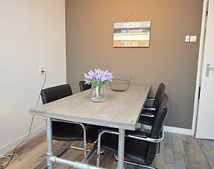 Stijlvolle eethoek in Motel Texel - Appartement 211/1P, De Koog, Texel, met bloemen op tafel.