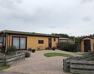 Chaletpark Bregkoog 253 in De Koog, Texel mit charmanter Holzfassade und einladender Terrasse, ideal fr einen entspannten Urlaub.