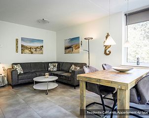 Stylish dining room in Type 3A vacation home, De Koog, Texel with wooden table and lots of natural light.