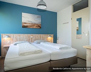 Bedroom of Type 3A accommodation in De Koog, Texel with soothing blue wall and cozy atmosphere.