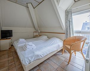 Schlafzimmer mit Doppelbett im Resort De Buteriggel - Apartment 0, De Koog, Texel, mit Blick auf die Umgebung.