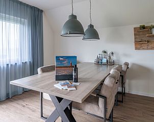 Modernes Esszimmer im Nieuwlanderweg 77, De Koog, Texel, mit groem Tisch und bequemen Sthlen, ideal fr gemtliche Mahlzeiten.