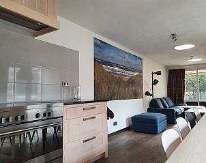 Comfortable living room in Orchismient 24, De Koog, Texel, with sofa and coastal landscape on the wall.