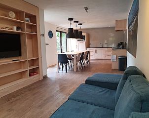 Open living space in vacation home Orchismient 24, De Koog, Texel, with kitchen and sitting area.