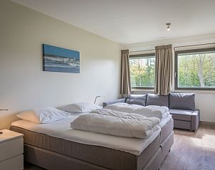 Spacious bedroom in Orchismient 24, De Koog, Texel, with double bed and garden view.