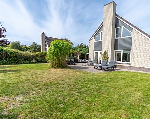 Spacious lawn at Holiday home Honeysuckle 61 in De Koog, Texel with sunny terrace for relaxation.