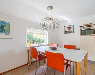 Dining area in Holiday home Honeysuckle 61, De Koog, Texel with modern art and designer lamp.