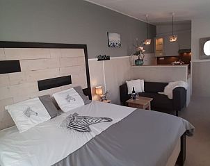 Attractive bedroom in Apartment Duinzee Texel, De Koog, with comfortable double bed and cozy sitting area.