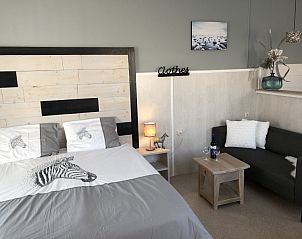 Cozy bedroom in Apartment Duinzee Texel, De Koog, with cozy sitting area and attractive decorations.