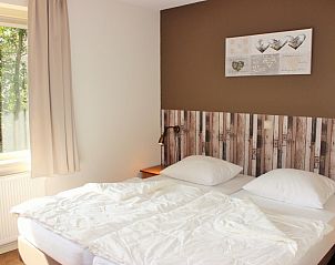 Schlafzimmer im reetgedeckten 6-Personen-Ferienhaus Eldorado Texel, De Koog, mit Doppelbett und Tageslicht.