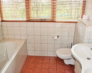 Modernes Badezimmer im reetgedeckten 6-Personen-Ferienhaus Eldorado Texel, De Koog, mit Badewanne und groem Fenster.
