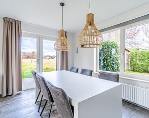 Dining room in Holiday home Honeysuckle 67 De Koog Texel with large table and garden view, perfect for family dinners on the Wadden Islands.