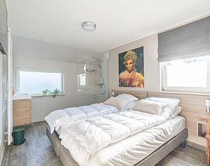 Vacation home Honeysuckle 67 De Koog Texel with comfortable bedroom and ensuite bathroom, ideal for rest on the Wadden Islands.