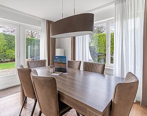Dining area in Holiday home Honeysuckle 49, De Koog, Texel, overlooking the green garden.