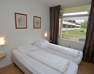 Schlafzimmer im Appartement Kerckeland 110, De Koog Texel, mit bequemen Betten und Gartenblick.