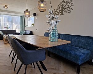 Cozy dining room in Holiday home Duinzee Texel in De Koog with wooden table and modern lighting.