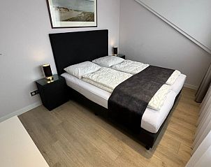 Comfortable bedroom at Holiday home Duinzee Texel in De Koog with stylish bed and atmospheric lighting.