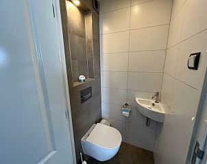 Stylish toilet in Holiday home Duinzee Texel in De Koog with sleek tiles and modern plumbing.