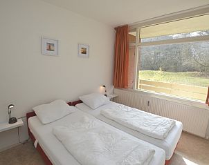 Komfortables Schlafzimmer im Apartment Kerckeland 28, De Koog, Texel mit Doppelbett und Blick auf die Natur.