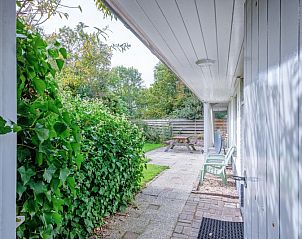 Schattige Veranda von Het Paviljoen, Ferienhaus in De Koog, Texel, umgeben von grner Natur.