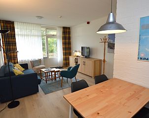 Spacious interior of Apartment Kerckeland 126 in De Koog, Texel, with dining area and view of the greenery.