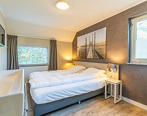 Bedroom with double bed in Holiday Home Honeysuckle 57, De Koog, Texel for a relaxing night's sleep.