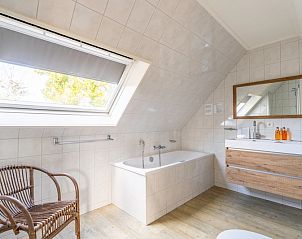 Spacious bathroom with bathtub in Holiday home Honeysuckle 57, De Koog, Texel for ultimate relaxation on the Wadden Islands.