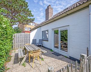Sunny terrace with wooden seating at 32a Castor vacation home, De Koog, Texel.