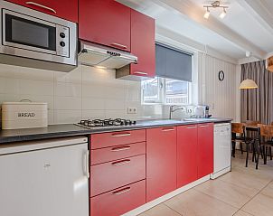 Modern kitchen in 32a Castor vacation home, De Koog, Texel, with red cabinets.