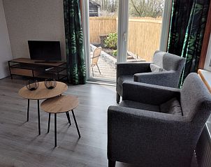 Cozy living room in Chalet Uit en Thuis, De Koog, Texel, with comfortable chairs and views of the terrace.
