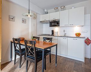 Dining area of Motel Texel Apartment with bath (B), De Koog, Texel with stylish furnishings and kitchen.