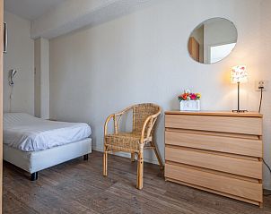Comfortable bedroom in Motel Texel Apartment with bath (B), De Koog, Texel with single bed and rattan chair.