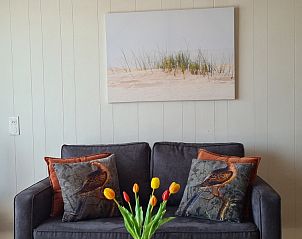 Stilvolle Sitzecke im Motel Texel Apartment Y, De Koog, Texel, mit Kunstwerken und bunten Kissen.