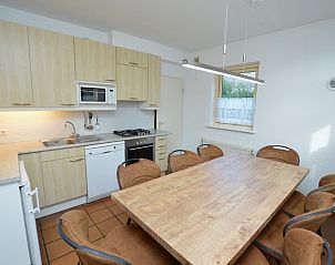 Modern kitchen in Holiday home Stappeland 199, De Koog, Texel, with wooden cabinets and spacious dining area.