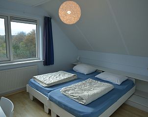 Spacious double room in Holiday home Stappeland 199, De Koog, Texel, with comfortable bed and view of nature.