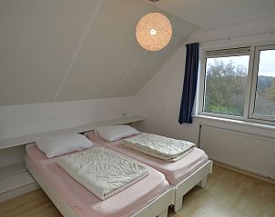 Bright bedroom in Holiday home Stappeland 199, De Koog, Texel, with two single beds and views of the green surroundings.
