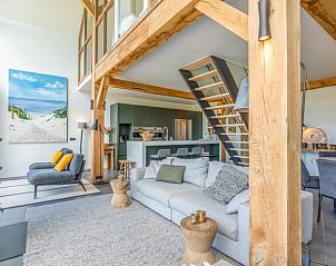 Moderne keuken en eetruimte in Vakantiehuisje in De Koog, Texel, met houten balken.